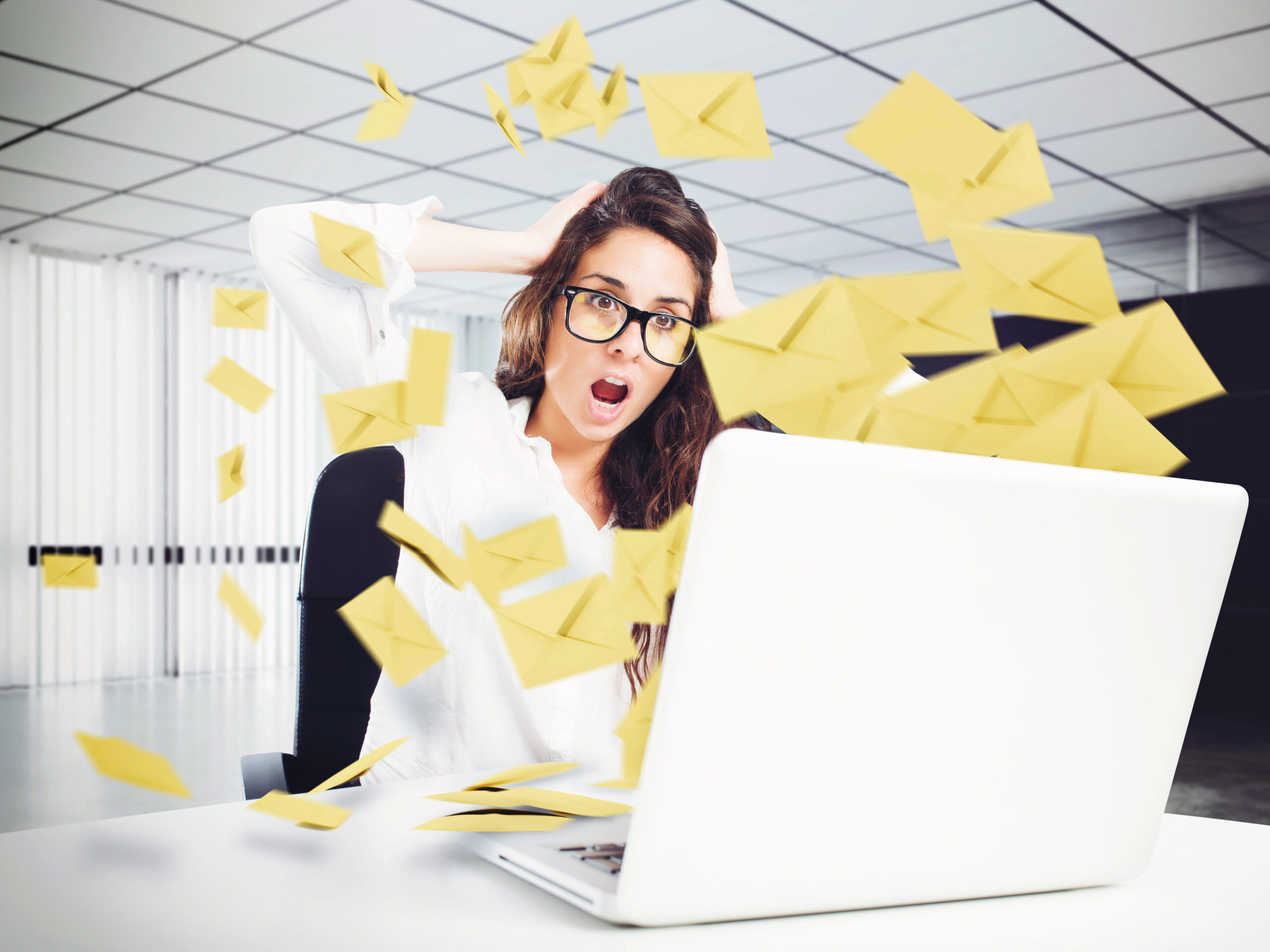 image of envelopes representing email flying out of laptop; woman with shocked face