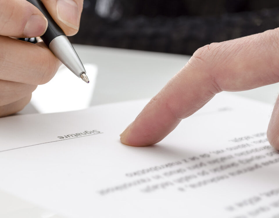 close up of hand signing contract
