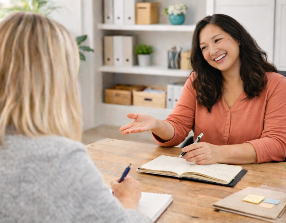 collaborative conversation between two women at wooden desk